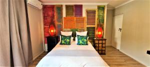 a bedroom with a bed with two pillows and a window at African Groove Camps Bay in Cape Town