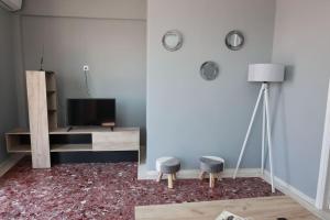a living room with a television and two stools at Beautiful apartment in Plomari in Plomarion