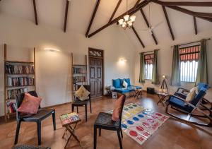 een grote woonkamer met stoelen en een tapijt bij SaffronStays Niramay, Torna-Rajgad - rustic pool villa with a gazebo and great forest views in Mārg Āsni