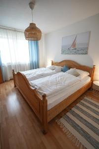 a large wooden bed in a bedroom with a sailboat in the window at Ferienwohnung Lieblingsplatz in Traunstein