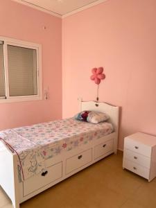 una camera da letto con un letto con un fiore sul muro di maison du bonheur en bord de mer avec piscine a Saïdia