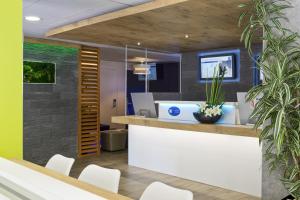 un ufficio con reception e sedie bianche di ibis budget Cannes Centre Ville a Cannes