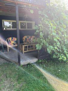 eine Veranda mit einem Sofa und einem Stuhl auf einer Terrasse in der Unterkunft Pušynas1 in Anykščiai