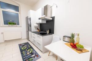 a white kitchen with a table and a counter top at 4-Zimmer Wohnung mit grandioser Aussicht in zentraler Lage in Hannover
