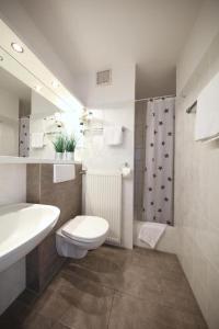 a bathroom with a toilet and a sink and a shower at Hotel Lammerts in Horn-Bad Meinberg