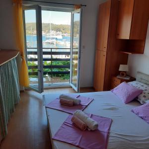 a bedroom with two beds and a large window at Apartments Bojana Rab in Rab