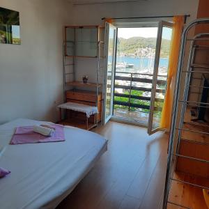 a bedroom with a bed and a balcony with a view at Apartments Bojana Rab in Rab