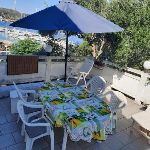 a table and chairs with an umbrella on a patio at Apartments Bojana Rab in Rab