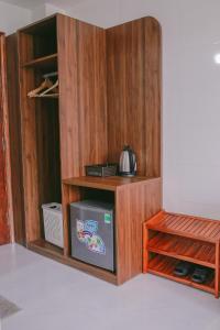 a wooden cabinet with a refrigerator in a room at Vagibi Hotel in Dong Hoi