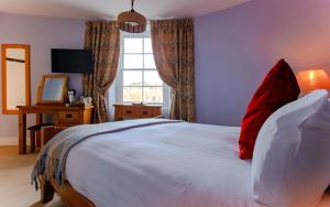 a bedroom with a large white bed with red pillows at The Ship in Dock Inn in Dartmouth