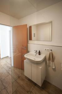 a bathroom with a sink and a mirror and a shower at Ferienwohnung Lieblingsplatz in Traunstein