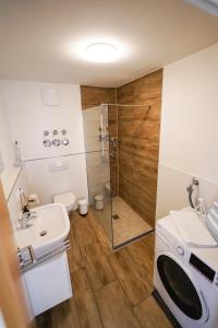 a bathroom with a shower and a sink and a toilet at Ferienwohnung Lieblingsplatz in Traunstein
