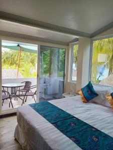 Island Life Maldives Retreat & Spa في Magoodhoo: غرفة نوم بسرير وفناء مع طاولة