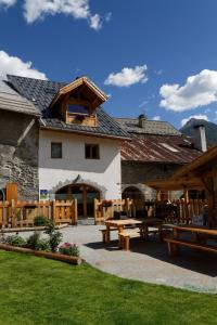 a building with picnic tables in front of it at Le Bacchu Ber in Briançon