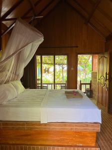 a bedroom with a large bed in a room at Banana cottages in Gili Air