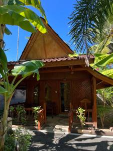 a wooden house with a thatched roof at Banana cottages in Gili Air