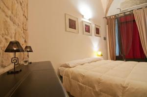 1 dormitorio con 1 cama y 1 mesa con lámpara en Tito Schipa B&B, en Lecce