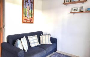 a blue couch against a white wall with pillows at Casa Chappell in Badolato