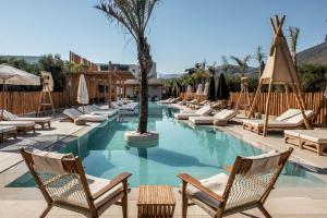 een zwembad met ligstoelen en een palmboom bij Indigo Inn Casa Adults Only in Chersonissos