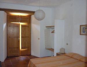 um quarto com uma cama e uma porta de madeira em B&B Calabria em Scigliano