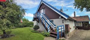 una casa con una escalera azul en el lateral de ella en Sodyba ant marių kranto, en Preila