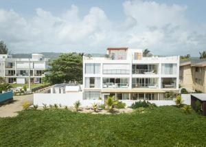 een afbeelding van een wit gebouw met een tuin bij Amazing Ocean Front - 2 bedroom Apartment (117 sq meters) in Cabarete