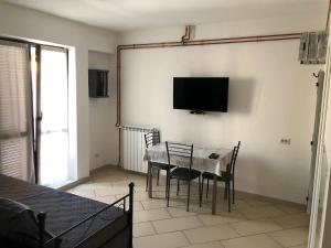 ein Esszimmer mit einem Tisch und Stühlen sowie einem TV in der Unterkunft Rent Apartment Sardegna in Porto Torres