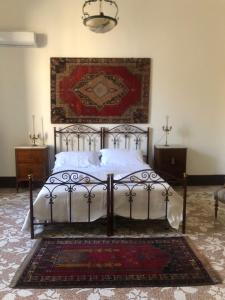 Palazzo Bernardini Suites في ليتشي: غرفة نوم مع سرير وسجادة على الأرض