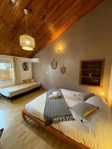 sypialnia z dużym łóżkiem i drewnianym sufitem w obiekcie Les Baroudeurs Hostel w mieście Saint-Pierre