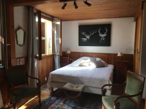 a bedroom with a bed and two antlers on the wall at Chalet Nicouski in La Salle Les Alpes