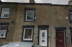 a brick building with a car parked in front of it at 4-Bedroom House Close to Barnsley Centre in Barnsley