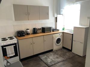 a kitchen with a washing machine and a washer at 4-Bedroom House Close to Barnsley Centre in Barnsley