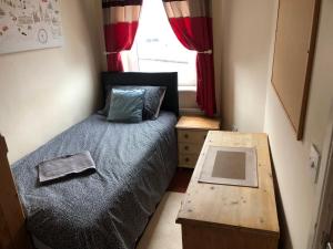 a small bedroom with a bed and a table at 4-Bedroom House Close to Barnsley Centre in Barnsley