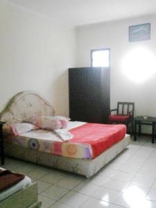 ein Schlafzimmer mit einem Bett mit einer roten Decke in der Unterkunft Liemas hotel in Pasuruan