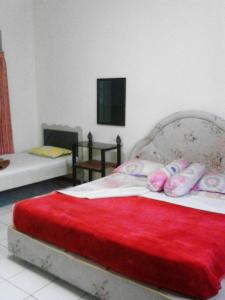 sypialnia z łóżkiem z czerwonym kocem w obiekcie Liemas hotel w mieście Pasuruan