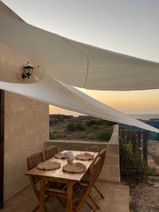 a table and chairs under a white canopy on a patio at La finestra a tramontana in Favignana
