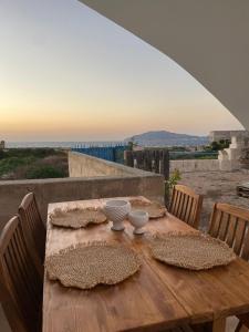 een houten tafel met twee kommen bovenop bij La finestra a tramontana in Favignana