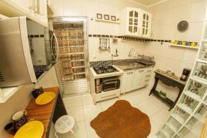 uma cozinha com armários brancos e um forno com placa de fogão em Quarto 25 Santana by OBA em São Paulo