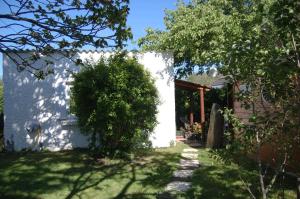 una casa blanca con un arbusto en el patio en Les Chambres de Kerzerho, en Erdeven
