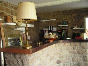 a room with a lamp on a stone wall at Les Chambres de Kerzerho in Erdeven
