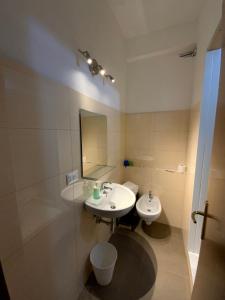 a white bathroom with a sink and a mirror at Hotel Naviglio in Marina di Pietrasanta