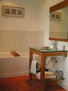 a bathroom with a sink and a bath tub at Les Chambres de Kerzerho in Erdeven