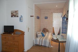 1 dormitorio con 1 cama, vestidor y TV en Les Chambres de Kerzerho en Erdeven