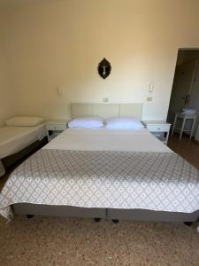 a bedroom with a large white bed with two tables at Hotel Naviglio in Marina di Pietrasanta