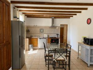 cocina con mesa, sillas y nevera en Les Célestins - Villa en Provence, en Carpentras
