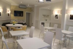 une salle à manger avec des tables, des chaises et une télévision dans l'établissement Hotel La Pace, à San Mauro Torinese