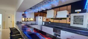 una grande cucina con armadi bianchi e ripiani neri di First line of the ocean, 3 bedrooms & Free wifi a Playa de las Americas