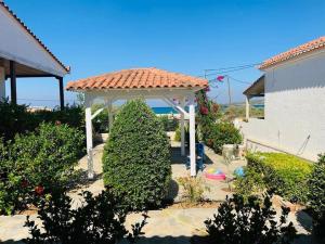 a gazebo in the middle of a yard at Familienfreundliches Fischerhaus am Strand in Porto Heli