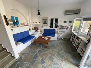 a living room with blue couches and a table at Familienfreundliches Fischerhaus am Strand in Porto Heli