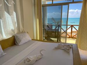 a bedroom with a bed with a view of the ocean at Equalia Rose hotel in Jambiani